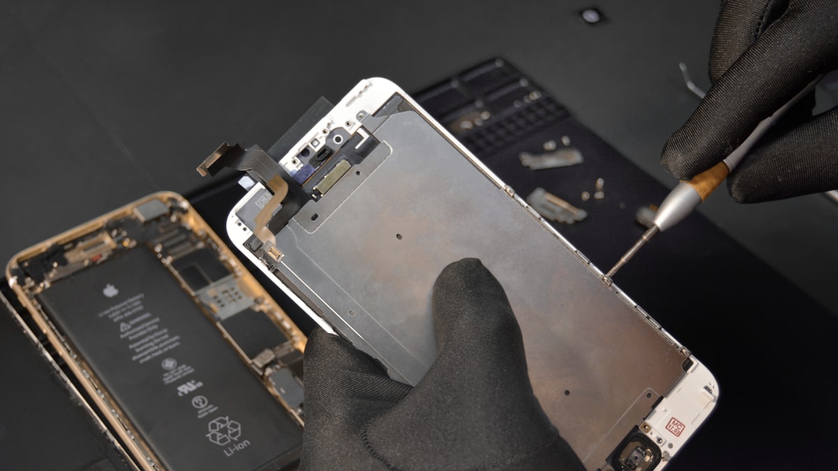 Persoana reparand un telefon mobil