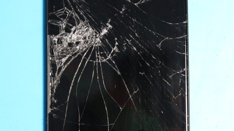 Ecran de smartphone spart pe suprafata albastra